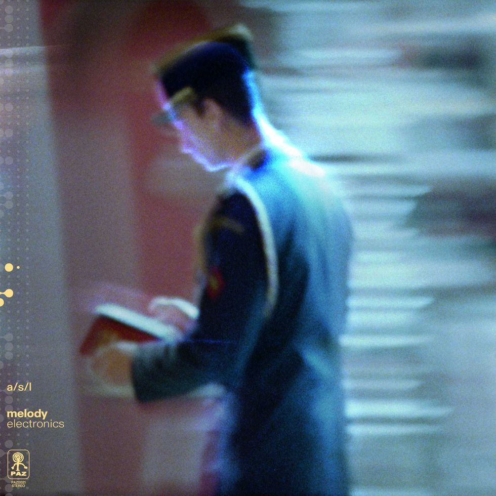 Blurred A/S/L in uniform, reading a book with a soft background.